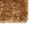 Close-up van de hoek van de bruine shaggy deurmat New Paulo Gold 030 200x300, met de grove, getextureerde vezels tegen een witte achtergrond.