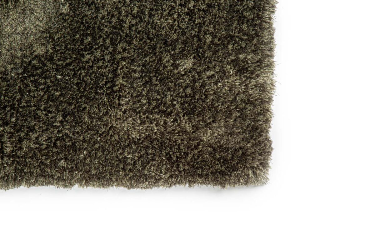 Close-up van de hoek van het Viterbo ST Hunter 421 200x300 donkerbruine shaggy tapijt met textuur tegen een witte achtergrond.