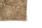 Een close-up van de hoek van de Viterbo ST Silver 119 200x300 beige, donzig tapijt op een witte achtergrond.