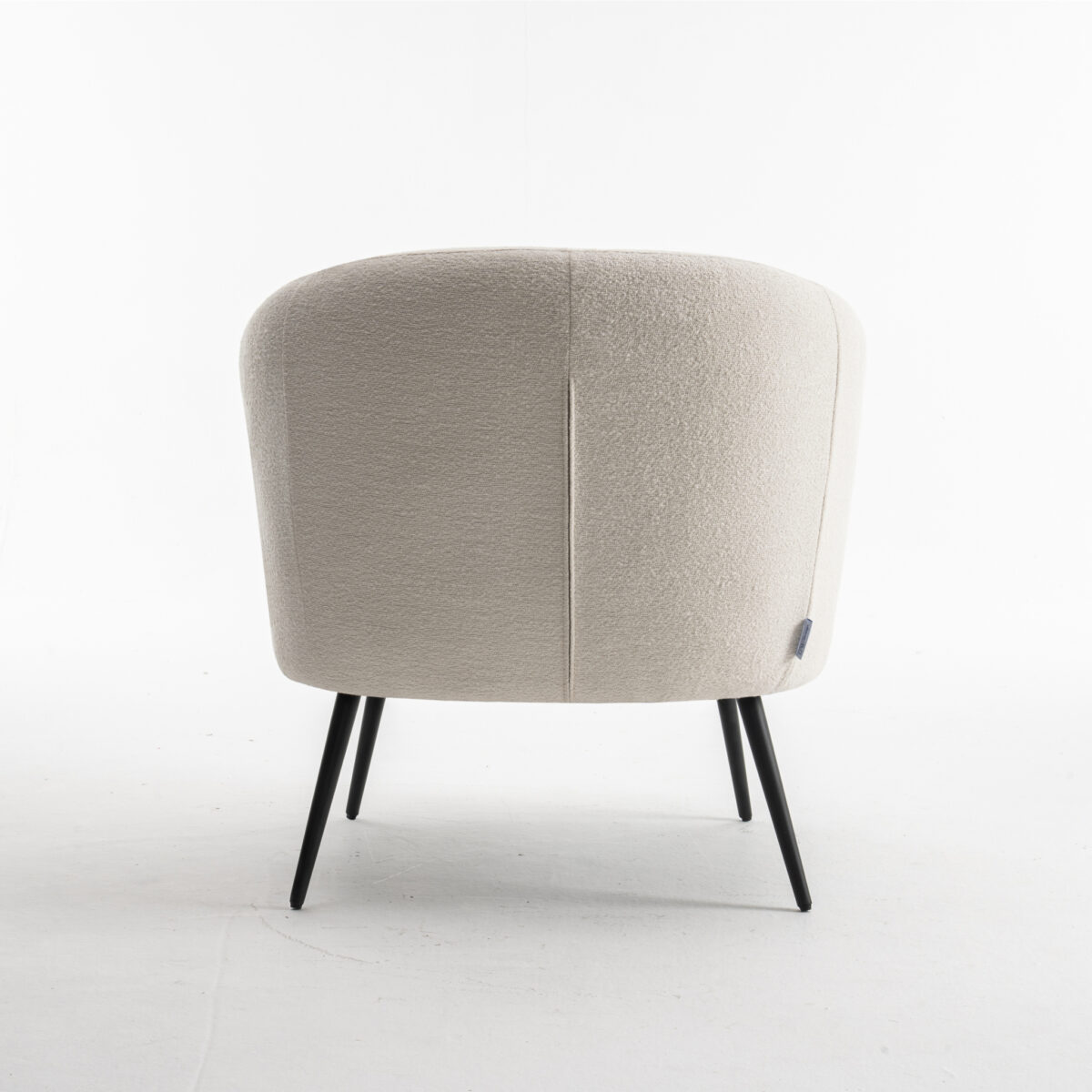 De Laura fauteuil Stof Teddy Ivory 101 is een beige gestoffeerde stoel met een gebogen rugleuning en slanke zwarte metalen poten, getoond vanaf de achterkant op een effen witte achtergrond.