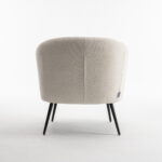 De Laura fauteuil Stof Teddy Ivory 101 is een beige gestoffeerde stoel met een gebogen rugleuning en slanke zwarte metalen poten, getoond vanaf de achterkant op een effen witte achtergrond.