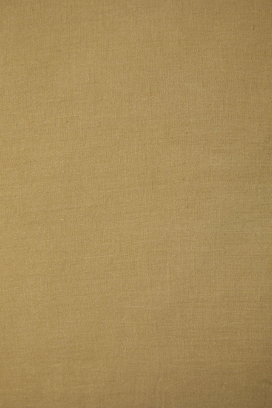 Een close-up van het Sierkussenhoes Scotty Goudbruin 60x40 cm laat de gele stofstructuur zien met een fijne, gelijkmatige weving en subtiele variaties in kleur en belichting.