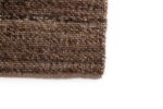 Close-up van het Bressano Brown 623 vloerkleed (170x230), met het bruin en zwart geweven patroon, de gedetailleerde textuur en de randstiksels tegen een witte achtergrond.