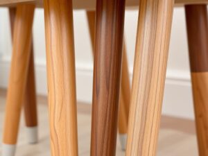 Close-up van verschillende eetkamerstoelen met houten poten die de natuurlijke houtstructuur tonen