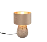 De Reality Tafellamp Kiran heeft een betonnen voet met textuur, een goudkleurig middenstuk en een zachtbeige stoffen kap. Als hij aanstaat, straalt hij een warm licht uit voor een moderne, uitnodigende sfeer.