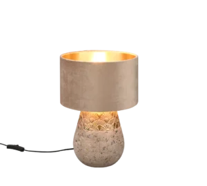 De Reality Tafellamp Kiran heeft een betonnen voet met textuur, een goudkleurig middenstuk en een zachtbeige stoffen kap. Als hij aanstaat, straalt hij een warm licht uit voor een moderne, uitnodigende sfeer.