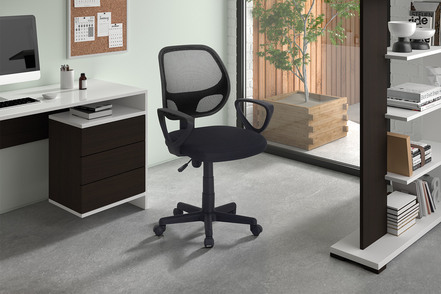 Een modern kantoor aan huis met de Bureaustoel 'Hippa' Mesh Zwart (1c) op wielen, een wit bureau met laden, computermonitor, boekenplanken en een groot raam met uitzicht op een potplant.