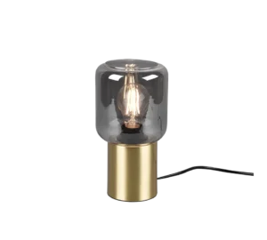 De REALITY Tafellamp NICO heeft een moderne cilindrische koperen voet en een helder glazen kap die een gloeiende gloeilamp onthult. De lamp wordt tegen een witte achtergrond weergegeven en heeft een zichtbaar zwart netsnoer.