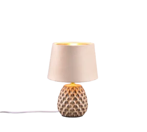 De REALITY Tafellamp ARIANA heeft een verlichte, getextureerde voet met patronen en een beige lampenkap. Een wit netsnoer komt uit de voet.