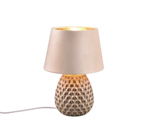 De REALITY Tafellamp ARIANA heeft een keramische voet met textuurpatroon en een lichtbeige stoffen lampenkap, verlicht en aangesloten op een wit netsnoer, afgebeeld geïsoleerd op een witte achtergrond.