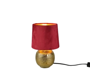 De REALITY Tafellamp SOPHIA heeft een gestructureerde ronde gouden voet met een dieprode fluwelen lampenkap. Als hij aanstaat, werpt hij een warmgeel licht en heeft hij een zwart elektriciteitssnoer dat aan de zijkant uitsteekt.