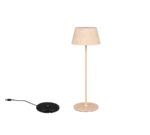 De Reality Tafellamp Suarez, een moderne beige lamp met een geplooide kap, staat naast een zwart rond apparaat met een USB-kabel op een effen witte achtergrond.