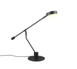 De TRIO Tafellamp Manduro is een moderne zwarte bureaulamp met een ronde voet en verstelbare arm, voorzien van een ronde lampenkap die zacht licht werpt tegen een effen witte achtergrond.