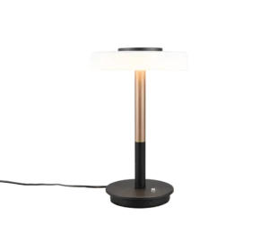 De TRIO Tafellamp Celeste heeft een ronde zwarte voet, een slanke zwarte en gouden steel, een platte ronde witte kap en is afgebeeld met een zichtbaar netsnoer.
