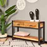 De TRIO Tafellamp Bale heeft een modern ontwerp met een cilindrische oranje voet en bijpassende ronde lampenkap. De lamp straalt een zachte gloed uit en heeft een zwart netsnoer tegen een effen witte achtergrond.