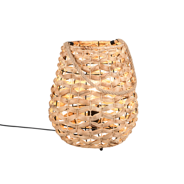 De REALITY Tafellamp JEAN is een ovaalvormige lantaarn van gevlochten rotan met een handvat van touw en een gloeilamp binnenin, die een warm licht verspreidt.