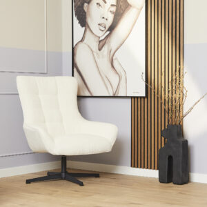 De Fauteuil Nora Off White loungestoel staat op een lichte houten vloer naast een zwarte abstracte vaas met gedroogde takken, onder een groot vrouwenportret op een muur met verticale houten latten.