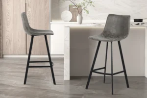Twee Barstoel 'Ozan' PU Grijs barkrukken (set van 2) met zwart metalen poten staan in een minimalistische keuken met lichthouten kasten, een wit marmeren aanrecht en decoratieve vazen met groen op de achtergrond.