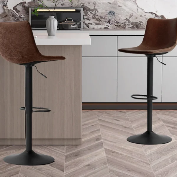 Twee Barstoel 'Trevi' PU Bruin barkrukken (set van 2) met zwart metalen onderstel staan in een moderne keuken met licht houten en witte kasten, een marmeren achterwand en een houten vloer met chevronpatroon.