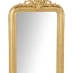 De wandspiegel Ema Wood Gold Colored heeft een rechthoekige vorm met een sierlijke gouden lijst, ingewikkelde details langs de bovenrand en een decoratief bloemen- en vaasmotief bovenaan.