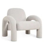 De Fauteuil Phiel - Bouclé Naturel is een moderne fauteuil met zachte, ronde vormen, dikke gebogen poten en armen en een minimalistisch eigentijds ontwerp, bekleed met natuurlijke boucléstof.