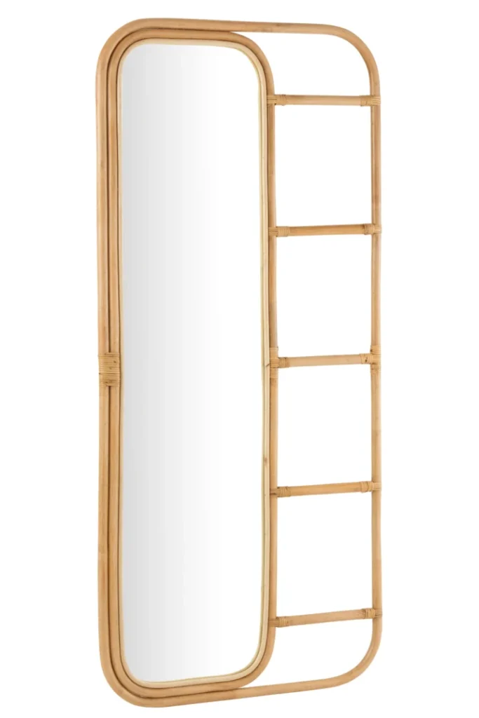 De Mirror-Ladder Rattan Natural is een hoge, rechthoekige spiegel met afgeronde hoeken en een licht rotan frame. De rechterkant heeft een ladderachtig verlengstuk met drie horizontale sporten.