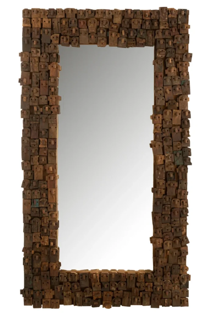 De MIRROR SYMA RECYCLED WOOD/MIRROR NATURAL LARGE heeft een rechthoekige vorm met een opvallend, grof frame gemaakt van verschillende gerecyclede houtblokken voor een rustieke, getextureerde look.