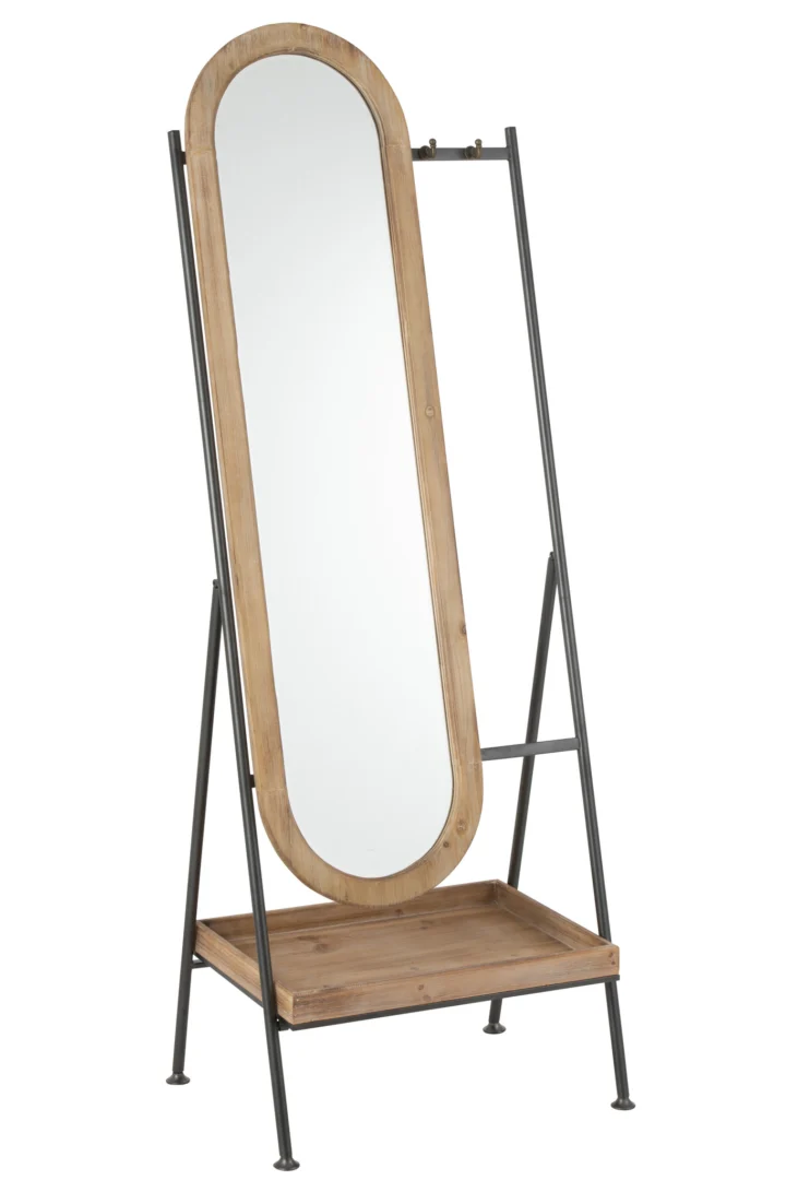 De spiegel Standing+Shelf Metal/Wood Brown is een ovale spiegel over de hele lengte met een licht houten frame, gemonteerd op een zwart metalen standaard met een rechthoekig houten opbergbakje aan de onderkant.