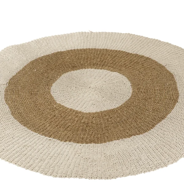 Het Vloerkleed Rond Zeegras Wit/Naturel Groot is een rond geweven tapijt met drie concentrische ringen: een binnenste crème cirkel, een middelste lichtbruine cirkel en een buitenste crème cirkel. De natuurlijke zeegrastextuur lijkt een beetje ongelijkmatig.