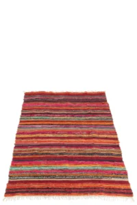 De Vloerkleed Chindi Katoen/Polyester Mix is een rechthoekig vloerkleed met levendige horizontale strepen in rood, oranje, geel, groen en blauw, met franje aan de korte randen.