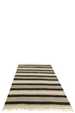 Het Vloerkleed Strepen/Stippen + Franjes Jute Ecru/Zwart is een rechthoekig vloerkleed met zwarte en ecru strepen met franjes op een witte ondergrond.