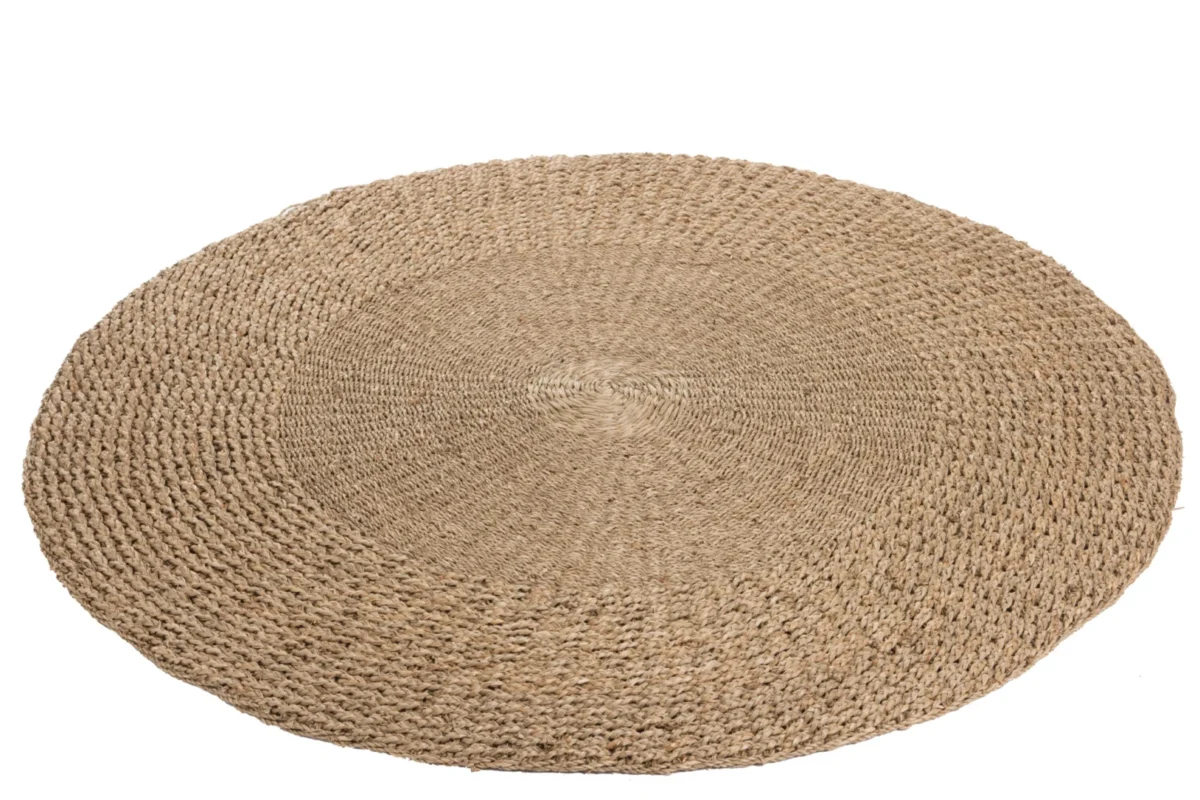 Het Vloerkleed Rond Gevlochten Zeegras Naturel is een rond, gevlochten zeegras vloerkleed in een natuurlijke beige tint, met geweven textuur en afgebeeld op een witte achtergrond.