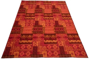 De Vloerkleed Afrikaans Polyacryl Mix Groot is een rechthoekig vloerkleed met een levendig geometrisch patroon in rode, oranje en roze tinten met herhalende ruitvormige en rechthoekige vormen.