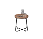 De Mirrors and More Bijzettafel JETTE is een klein rond bijzettafeltje met een houten blad en zwarte metalen poten, met daarop een glazen karaf, twee glazen en een rechthoekig zwart object.