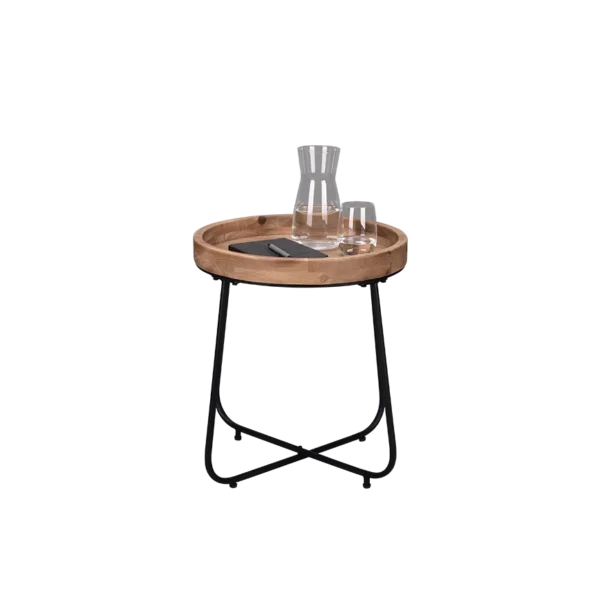 De Mirrors and More Bijzettafel JETTE is een klein rond bijzettafeltje met een houten blad en zwarte metalen poten, met daarop een glazen karaf, twee glazen en een rechthoekig zwart object.