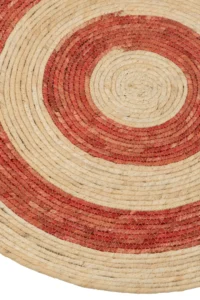 Een close-up van de Vloerkleed Rond Cirkels Maïsschil Oranje/Rood Medium (Set van 2) toont de geweven concentrische cirkels in natuurlijke beige en oranjerode tinten, die de gedetailleerde verweven vezelstructuur benadrukken.
