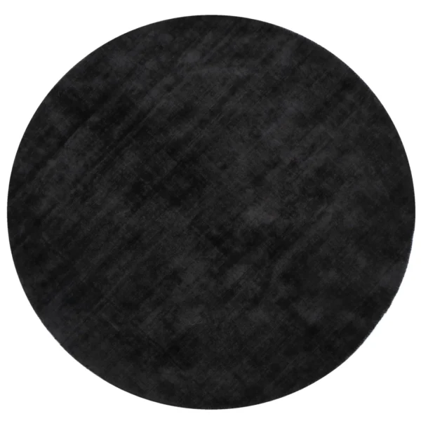 Het Vloerkleed Rond Handgemaakt Viscose Zwart is een groot, rond zwart vloerkleed van handgeweven viscose, met een zachte, fluweelachtige textuur met subtiele schaduwvariaties over het oppervlak.