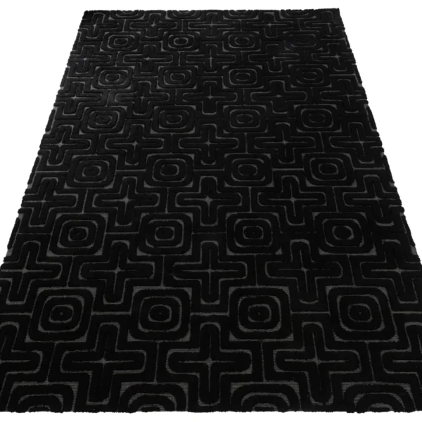 Het Vloerkleed Reliëf Viscose Zwart is een rechthoekig zwart vloerkleed met een geometrisch patroon van elkaar kruisende lijnen, cirkels en vierkanten in donkergrijze tinten.