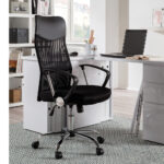 In een modern kantoor aan huis zit de Bureaustoel 'Max' Mesh Zwart aan een wit bureau met een laptop, een open boek en een kopje. Planken met boeken en decor staan op de achtergrond op een lichtgekleurd tapijt.