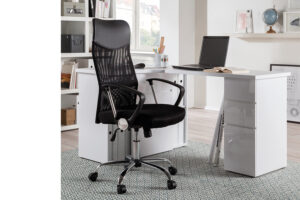 In een modern kantoor aan huis zit de Bureaustoel 'Max' Mesh Zwart aan een wit bureau met een laptop, een open boek en een kopje. Planken met boeken en decor staan op de achtergrond op een lichtgekleurd tapijt.