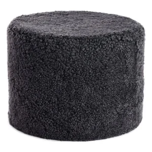 De Poef Schapenvacht Krullend Korte Wol M21 is een ronde voetenbank in donkergrijs, met een zachte, gestructureerde, fleece-achtige stoffen bekleding en afgebeeld tegen een witte achtergrond.