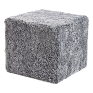 De Poef Schapenvacht Krullend Korte Wol M08 is een zachte, grijze, kubusvormige poef met een pluche, donzig oppervlak.