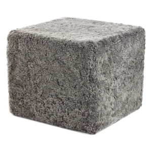 De Poef Schapenvacht Krullend Korte Wol M12 is een grijze, kubusvormige voetenbank bekleed met zachte, ruige stof met structuur.