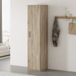 Een moderne slaapkamer met de Opbergkast 'Mike' 40 cm 1 deur Sonoma, een wandhaak met een geruit overhemd en gestreepte tas, planten en een bed met wit beddengoed bij een groot raam.