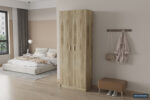 Een moderne slaapkamer met een laag bed, SALE - Opbergkast 'Space' 2 deuren en 5 legplanken Sonoma (1c) houten kledingkast, wandhaken met jas en tas, een bank, groot raam met gordijnen, lichte houten vloeren en neutrale muren.