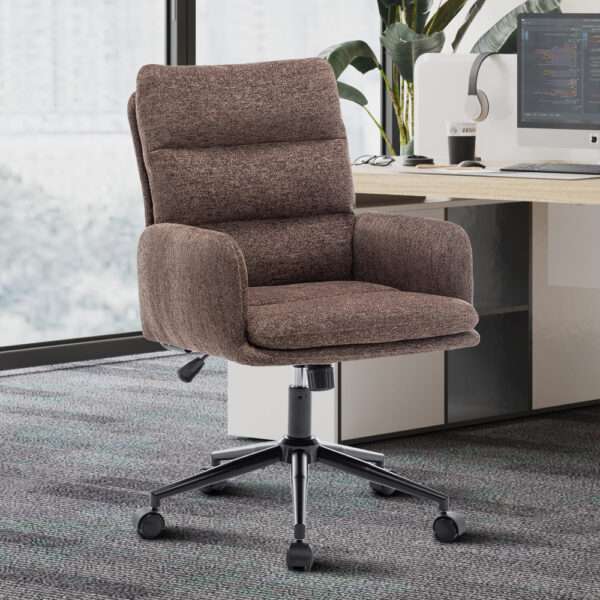 De Bureaustoel 'Aimé' Stof Fabb Raven 45 Bruin staat voor een modern wit bureau met een computer, planten en kantoorartikelen in een lichte werkruimte met vloerbedekking.