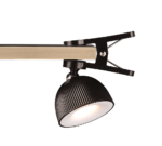 De REALITY Tafellamp MAXIMA is een moderne zwarte klemlamp met een geribbelde kap die op een houten oppervlak wordt geklemd en licht naar beneden werpt.
