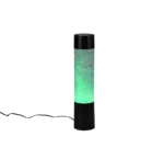 De REALITY Tafellamp GLITTER is een hoge cilindervormige lamp met een zwarte voet en bovenkant, met groen gloeiende vloeistof en drijvende glitters, gevoed door een zwart snoer.