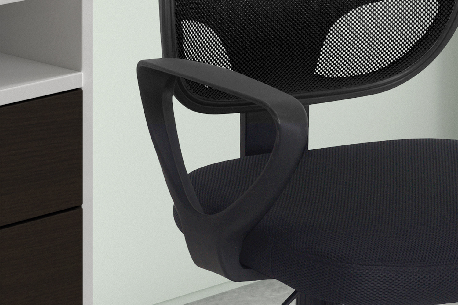 Close-up van de Bureaustoel 'Hippa' Mesh Zwart (1c), een zwarte bureaustoel met netrugleuning en kunststof armleuningen, geplaatst naast een bureau met zowel donkere als lichte laden.