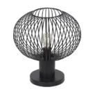 De TRIO Tafellamp Gila heeft een moderne ronde zwarte metalen draadkooi kap met een zichtbare gloeilamp, op een cilindervormige zwarte voet.